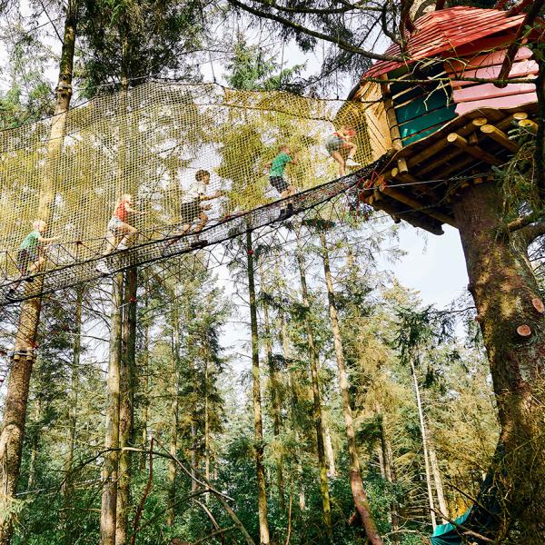 Besuche den wildesten Spielpark im Wald und erhalte einen coolen Adventure Badge für deinen Be Happy Pass. Macht es wie diese Kinder und rennt über die langen Hängebrücken von Baumhaus zu Baumhaus in den Baumkronen. Das ist ein Aktivurlaub für Familien mit Kindern.