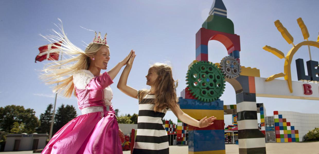Topattraktion for børn. Prinsesse giver high five til barn foran LEGOLAND® Portalen